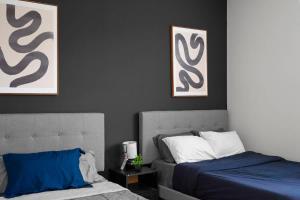 シャーロットにあるUpscale King 3BR Suite Uptown Charlotteのベッドルーム1室(ベッド2台付)が備わります。壁には絵画が飾られています。 +11枚の写真