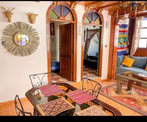 a living room with a table and chairs and a couch at étage 2 avec terrasse vue sur mer in El Jadida