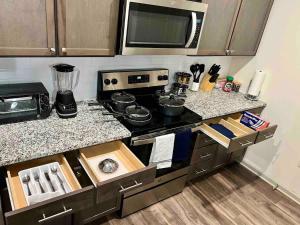 a kitchen with a stove and a counter top at Upscale King 3 Bed Suite to Uptown Charlotte in Charlotte