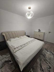 a bedroom with a large white bed with a light at Apartament Rosenau in Râşnov