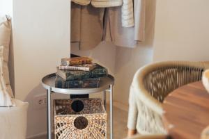 a side table with books on it next to a chair at Trullo Anteros in Alberobello