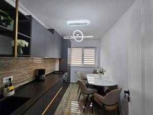 a kitchen with a table and chairs in a kitchen at Apartament Rosenau in Râşnov +15 photos