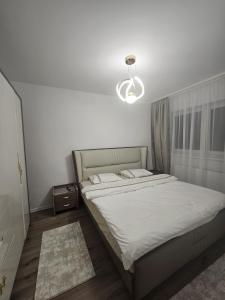 a bedroom with a large bed with a light at Apartament Rosenau in Râşnov