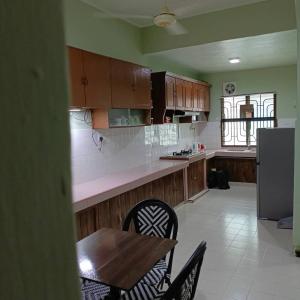 a kitchen with a table and chairs and a refrigerator at Newly Renovated Danau Kota Terrace House in Kuala Lumpur