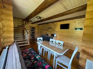 a dining room with a table and chairs in a cabin at Сонячна долина in Negrovets +16 photos