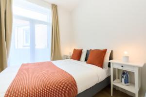 a bedroom with a bed with orange pillows and a window at Apartment Forest Center 2 in Brussels +10 photos