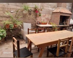 a table and chairs in a patio with a brick oven at Hostal 'La Cholita María' in Humahuaca +8 photos