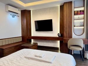 a hotel room with a bed and a tv at Hami LakeView Service Apartment in Hanoi