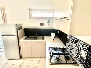 a kitchen with a stove and a white refrigerator at Casa Imelde al lago in Onno