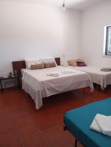 two beds in a room with white walls at Casa Ladino no Campo in Monte dos Pelados