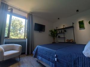 a bedroom with a blue bed and a chair and a window at Sogno tra le Torri in San Gimignano