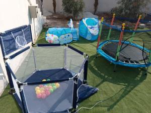 two trampolines with two trampolines with balls on the grass at شاليه ومزرعة طبقة فحل Chalet Pella in Khirbat al Ḩammah