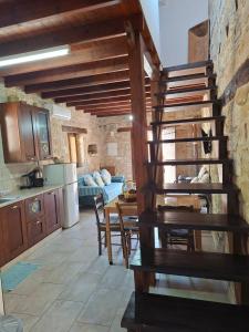 a kitchen and dining room with a wooden spiral staircase at Symela's Nest in Anoyira +16 photos