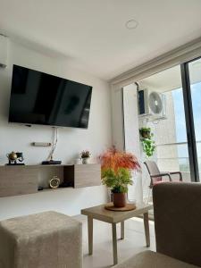 a living room with a tv and a couch and a table at Villas del mar in Cartagena de Indias