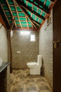 uma casa de banho com WC e tecto em madeira em Mannora Resorts em Maraiyūr mais 31 fotografias