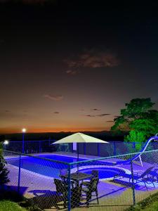 ein Zaun mit einem Picknicktisch und einem Sonnenschirm bei Nacht in der Unterkunft Finca Hotel Resplandor Quindiano - Eje Cafetero Quindío in Montenegro