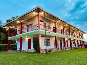 a large building with red and white paint at Finca Hotel Resplandor Quindiano - Eje Cafetero Quindío in Montenegro +48 photos