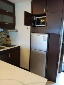 une cuisine avec un réfrigérateur et un micro-ondes dans l'établissement Stylish seaside Apartment on Laguna GOLF Course, à Bang Tao Beach