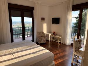a bedroom with a bed and a balcony at Hospedium Hotel Juan II in Toro