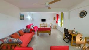 a living room with a red couch and a table at Maison de charme avec vue sur la mer à Sainte-Marie in Sainte-Marie