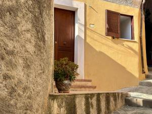a house with a potted plant in front of a door at Appartamento Le Grotte in Belmonte Calabro