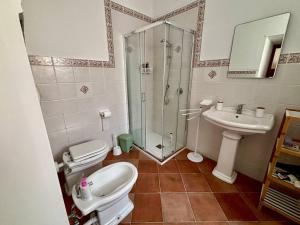 a bathroom with a shower and a toilet and a sink at Appartamento Le Grotte in Belmonte Calabro +5 photos