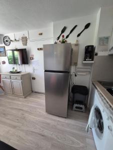eine Küche mit einem Kühlschrank aus Edelstahl in der Unterkunft Havre de paix appart climatisé,piscine,wifi in Le Barcarès + 12 Fotos
