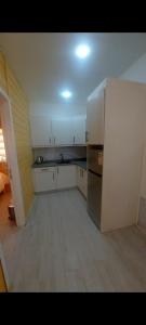 a kitchen with white cabinets and a stainless steel refrigerator at اكواخ ارض الخير in Ajloun