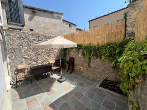 a patio with an umbrella and a table and chairs at La casa de la tía Guille in Medranda