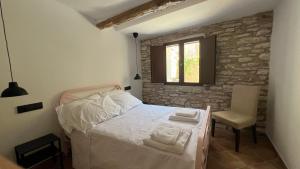 a bedroom with a bed and a chair and a window at La casa de la tía Guille in Medranda