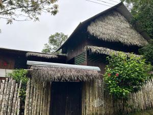 una casa con techo de paja y valla en Cabañas Mashcopiro Amazonas, en Puerto Nariño