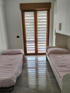 Habitación con 2 camas y ventana con persianas. en casa vitmont, en Castel di Sangro