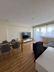a living room with a table and chairs and a television at Rooftop 1 bed sleeps 4 in Luxembourg