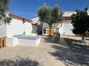 a bed sitting on a patio in front of a house at Cantinho do Baloiço in Vila Viçosa
