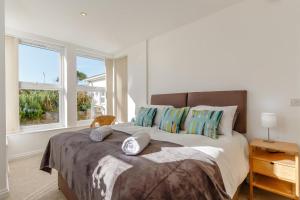 a bedroom with a large bed with two windows at 1 Seabirds House in St Ives