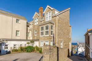 a large brick house with a stone wall at 1 Seabirds House in St Ives