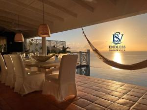 Tortola IslandEndless Summer Villa的一间带桌椅和吊床的用餐室