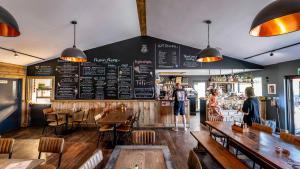 a restaurant with tables and a menu on the wall at Whitemills Wake and Aqua Park Lodge Three in Richborough