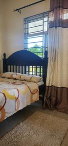 a bedroom with a bed and a window at Zuri Zen Villa in Dar es Salaam