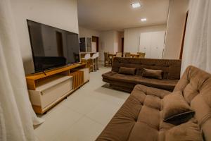 a living room with two couches and a flat screen tv at Casa Mirafeliz in Fernando de Noronha