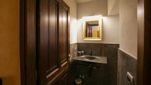 een badkamer met een wastafel en een houten deur bij Casa di Sant'Anselmo Aosta - Le Volte in Aosta +27 foto's