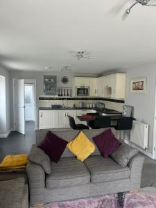 a living room with a couch and a kitchen at 2 bedroom bungalow, 15 minutes to Alton Towers, dog friendly in Wetleyrocks