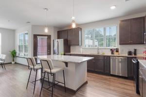 ウェイクフォレストにあるLuxe King 3 Bedroom Suite in North Raleigh NCのバースツール付きの大きな島のあるキッチンが備わります。