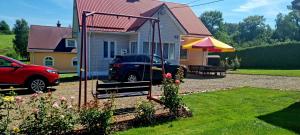 a car parked in a yard next to a house at Zielona Żabka in Polańczyk