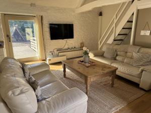a living room with a couch and a table at The Parlour Cotswolds Farm Stay With Pool in Lechlade