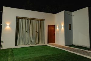 a house with a green lawn in front of a window at Casa Mirafeliz in Fernando de Noronha