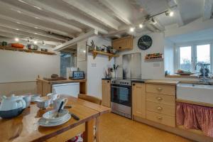 cocina con mesa de madera y encimera en Ty Capel Carmel, en Llanfachreth 6 fotos más