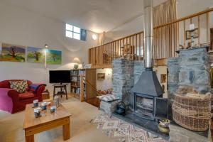 una sala de estar con una gran chimenea de piedra. en Ty Capel Carmel, en Llanfachreth