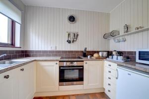 Una cocina con gabinetes blancos y un fregadero. en Shippon, en Walton West 5 fotos más