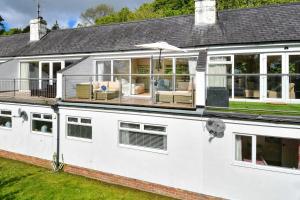 une maison blanche avec un porche ouvert avec un patio dans l'établissement 4 Glyn y Marian, à Llanbedrog